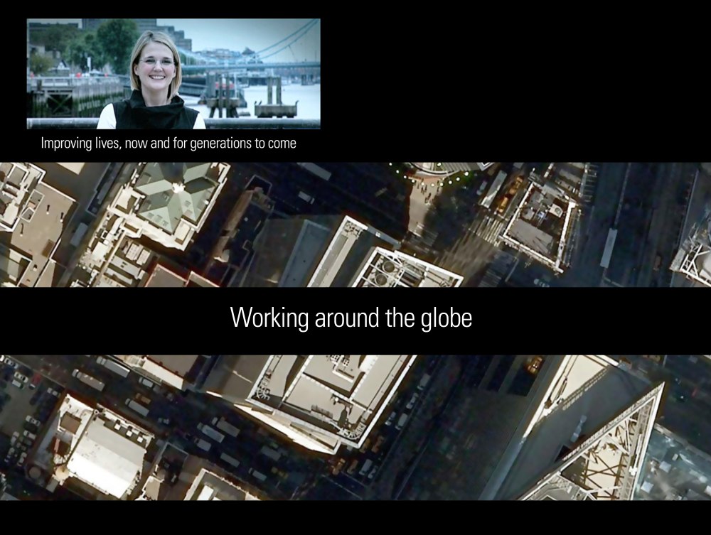 Balfour Beatty AGM Film — a colleague speaking to camera beside the Thames, over aerial footage of London office buildings, captioned "Working around the globe"